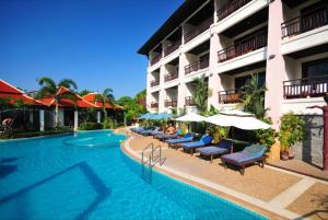 a hotel with a swimming pool with chairs and umbrellas at Aonang Orchid Resort in Ao Nang Beach