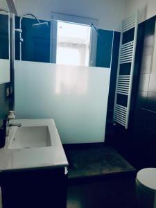 マティーノにあるAppartamento Via del Mareのバスルーム(白い洗面台、窓付)