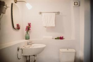 a white bathroom with a sink and a toilet at Celestia Traditional Houses in Keramoto