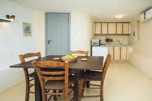 a dining room table with chairs and a bowl of fruit on it at Celestia Traditional Houses in Keramoto
