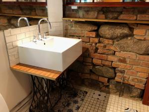 a white sink in a bathroom with a brick wall at Station Villa Vimmerby in Vimmerby +46 photos