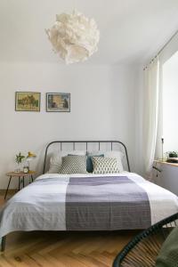 ein weißes Schlafzimmer mit einem Bett und einem Kronleuchter in der Unterkunft Bednarska Apartment in Warschau