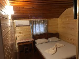 a small bedroom with a bed in a wooden cabin at Pension AMIRA in Costinesti