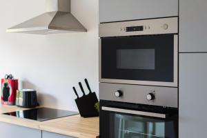 uma cozinha com um fogão e um micro-ondas em vilamaria apartment em Porches