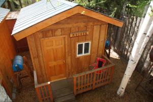 a wooden play house with a sign that reads inside at Sven's Basecamp Hostel in Fairbanks