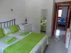 ein Schlafzimmer mit einem großen Bett mit grünen Kissen in der Unterkunft Brijon apartment in Moraira