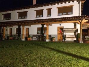 a large white house with a porch and a yard at La Llastra de Garaña in Llanes