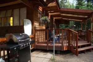 a porch of a cabin with a grill and a snowboard at Sven's Basecamp Hostel in Fairbanks