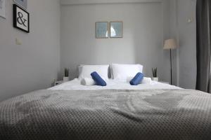 a white bed with blue pillows in a bedroom at Rita's home in Chania