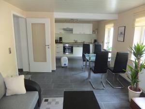 a living room with a table and chairs and a kitchen at Ferienwohnung Weserberglandblick in Hameln