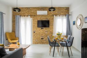 a living room with a table and chairs and a brick wall at Deluxe Town Hall Square Flat in Historical Center 3 in Corfu