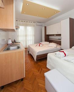 een keuken met 2 bedden en een wastafel in een kamer bij Apartmani Šarić in Tučepi