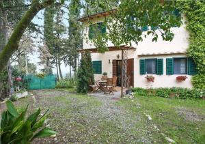 a small white house with green shutters and a patio at Chiantihouse near Florence in Montespertoli