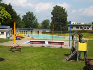 una gran piscina con bancos en un parque en Ferienwohnung Weserberglandblick en Hameln