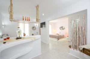 a white bathroom with a tub and a bedroom at Naxos Hotel Poseidon in Naxos Chora