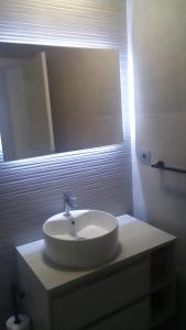 uma casa de banho com um lavatório branco e um espelho. em Edificio Attikos em Playa de Gandia