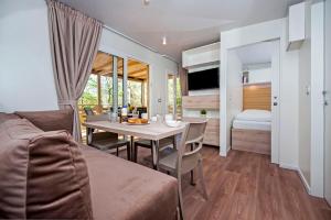ein Wohnzimmer mit Tisch und ein Schlafzimmer in der Unterkunft Eurocamp Mobile Homes at Campsite Puntica in Funtana
