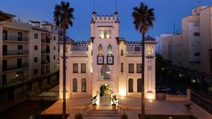 un grande edificio bianco con torre dell'orologio di notte di Hotel Kazar a Ontinyent