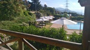 vistas a una piscina con sombrillas y una piscina en Refugios Olmue Santa Teresa, en El Maqui