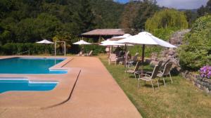 a swimming pool with chairs and umbrellas next to at Refugios Olmue Santa Teresa in El Maqui