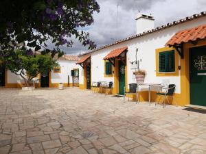 un grupo de edificios con sillas y mesas en un patio en Casa Vitória Guest House, en Évora