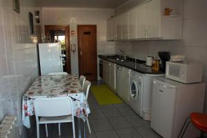 a kitchen with a table with chairs and a refrigerator at Arco Da Porta Nova in Braga