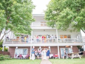 a group of people standing on the balcony of a house at Blue Heron Inn - A Bed and Breakfast LLC in Solomons