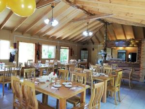 una grande sala da pranzo con tavoli e sedie in legno di Cabañas Aguas Claras a Pinto