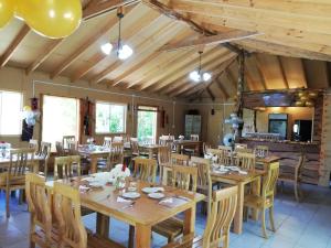 comedor grande con mesas y sillas de madera en Cabañas Aguas Claras, en Pinto