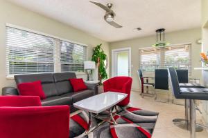 a living room with a black couch and red chairs at Beach & Waterway RFV Resort BB in Hillsboro Beach