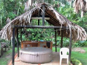a small hut with a barrel and a chair at Posada turística Quenari Wii in Mitú