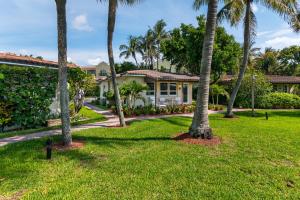 a row of palm trees in front of a house at Beach & Waterway RFV Resort BB in Hillsboro Beach