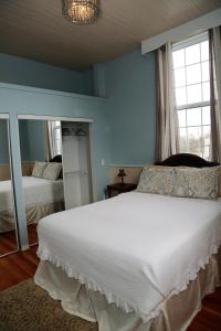 a white bed sitting in a bedroom next to a window at EMPIRE INN AND SUITES in Bloomfield