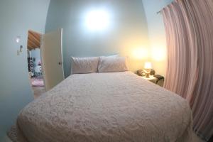 a bedroom with a bed with a white bedspread at Chin Cozy@ Rhyne Park in Montego Bay