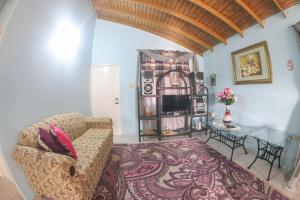 a living room with a couch and a table at Chin Cozy@ Rhyne Park in Montego Bay