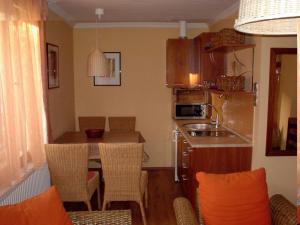 a kitchen with a table and chairs and a kitchen with a sink at Örökzöld Apartmanok Balatonfenyves in Balatonfenyves