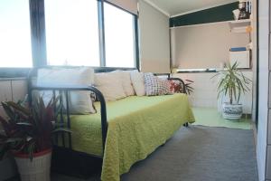 een slaapkamer met een bed met witte kussens en planten bij River & Ocean Studio in Porto