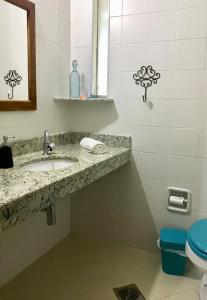 uma casa de banho com um lavatório e um WC em Chalés de Valfena em São Francisco Xavier