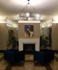 a living room with a fireplace and a chandelier at Quest Wellington Serviced Apartments in Wellington