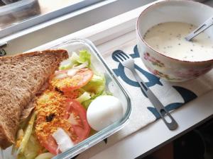 un piatto di cibo con un panino e una ciotola di zuppa di Cong Sen Backpackers Hostel a Città di Taitung Altre 20 foto
