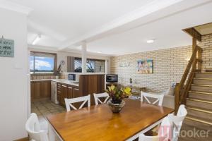 a kitchen and dining room with a table and chairs at Peninsula Court 6 - LJHooker Yamba in Yamba