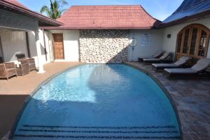 a large swimming pool in front of a house at Shipwatcher Studio w/Mezzanine in Ocho Rios