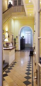 a hallway with yellow walls and a staircase with a table at Sevilla Home Hotel in Buenos Aires