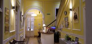 a hallway with yellow walls and an archway in a building at Sevilla Home Hotel in Buenos Aires