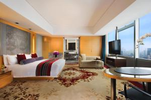 a hotel room with a large bed and a television at The Longemont Shanghai in Shanghai