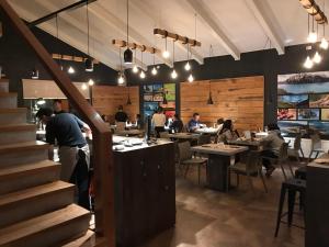 a restaurant with a staircase and people sitting at tables at Costanera Apart in Chile Chico