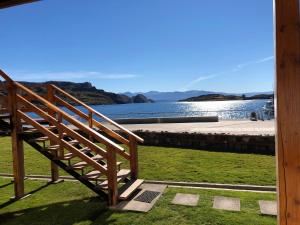 a wooden staircase with a view of a body of water at Costanera Apart in Chile Chico
