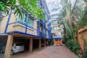 a building with a blue balcony and a parking lot at Silom Convent Garden - SHA Extra Plus in Bangkok
