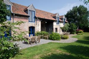 a house with a table and chairs in the yard at De Zwarte Stok in Riemst