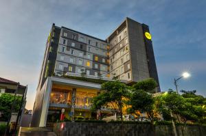 a tall building with a clock on top of it at Yello Hotel Jemursari in Surabaya